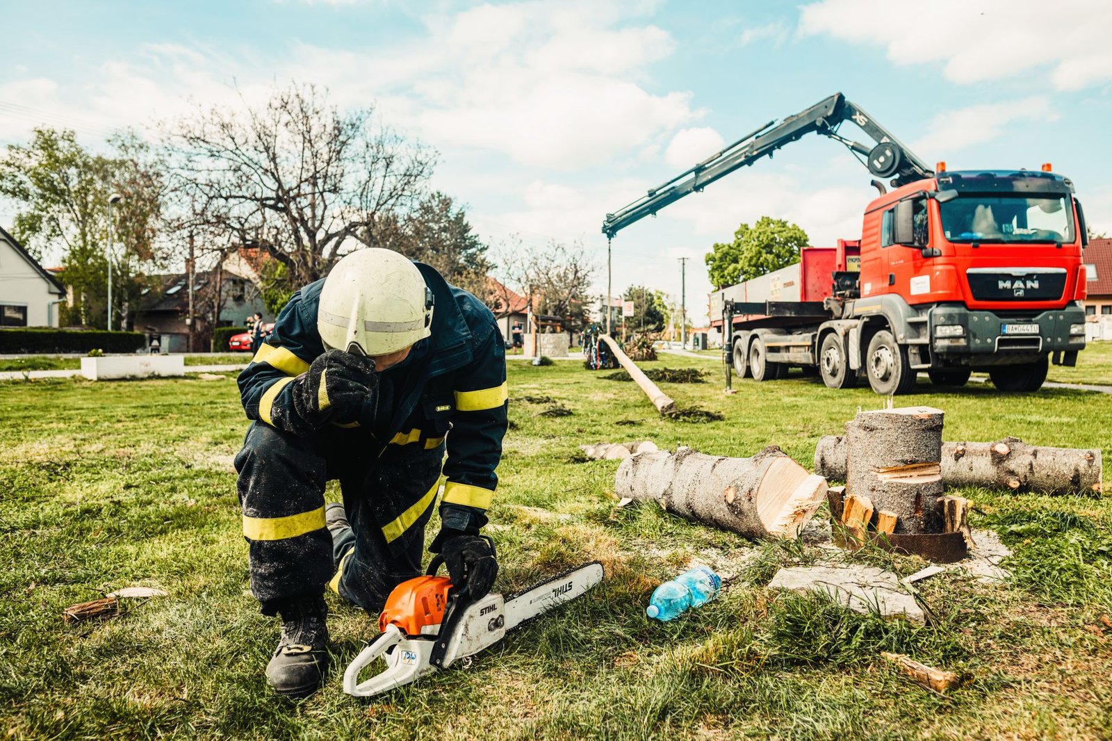 Arborist removing a large tree from a residential yard near Fort Liberty, NC
