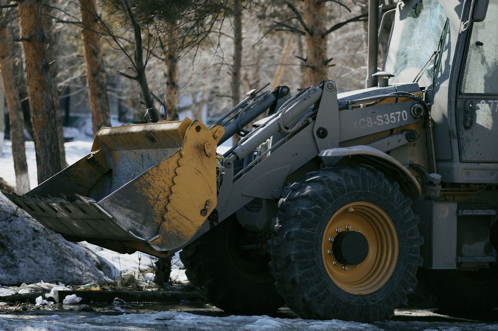 Excavator pulling a tree stump and its roots out of the ground